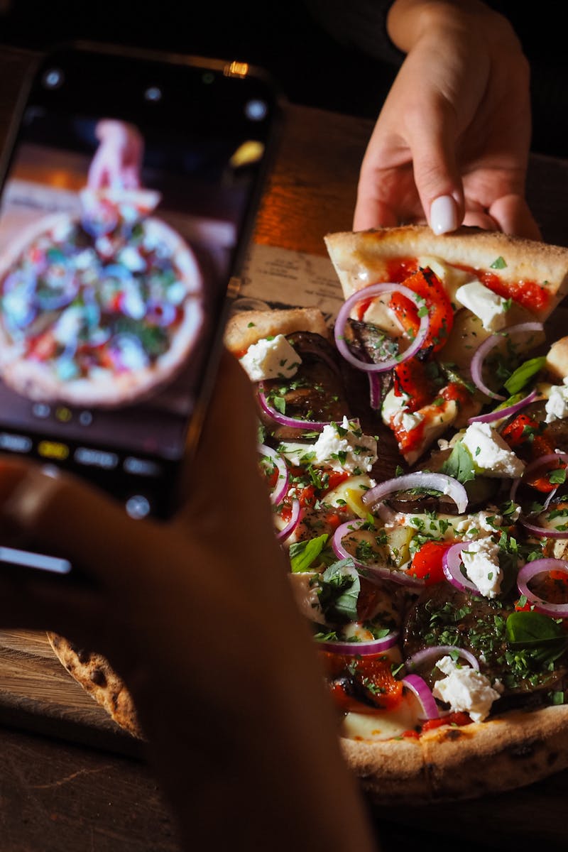 Close-up of gourmet pizza with toppings captured with a smartphone for food photography.